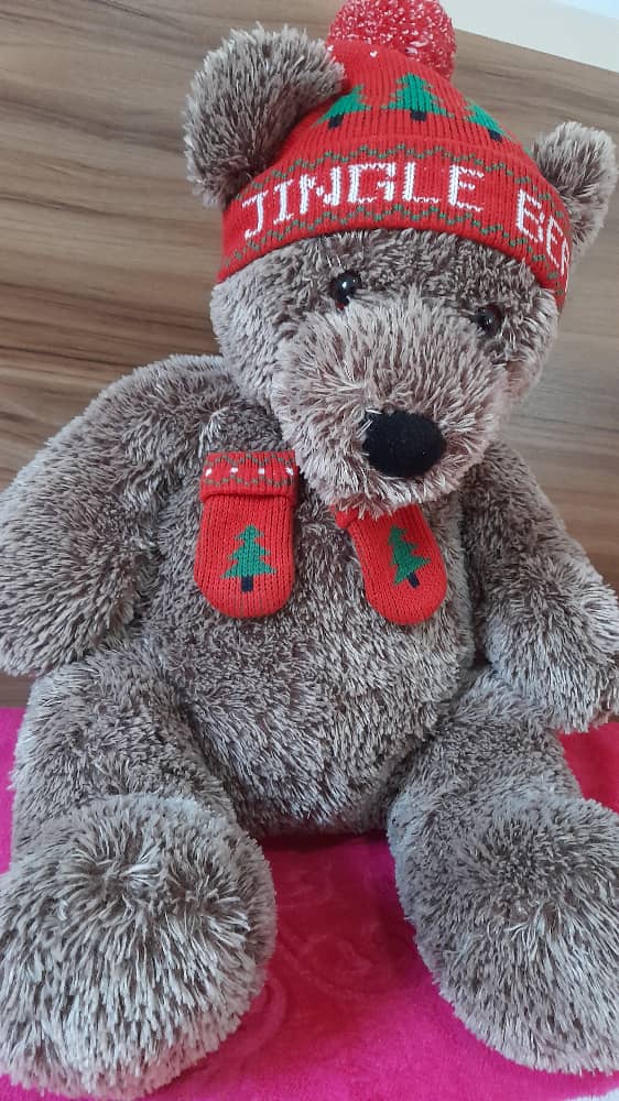 Teddy Merry Christmas  Joli nounours teddy "merry christmas" avec son charmant bonet et son joli noeud imprimé de motifs de sapin et de flocons de neiges pour vos cadeaux de noël et de fin d